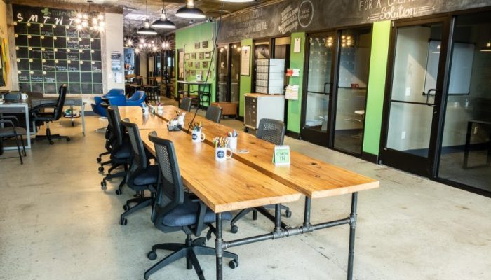 TBF Building-30 A photo taken inside the Biz Foundry's Cookeville coworking space. A wooden tale with mugs filled with pens and markers. The table is surrounded by office chairs.